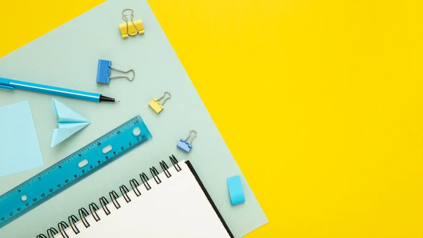 Anordnung von Schreibwaren auf gelbem Hintergrund